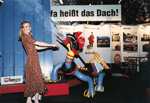 Ideen muß man haben, sagten sich die Standgestalter der Prefa GmbH und schufen diesen farbig-fröhlichen Spenglerdrachen. Nicole Angler, Tochter von Geschäftsführer Reinhard Angler, stellte sich dem Rauch ausstoßenden, blechernen Untier unerschrocken entgegen. Manchem Messebesucher werden auf diese Weise die hier präsentierten Produkte besonders gut in Erinnerung bleiben.