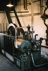 Kernstück der Dampfwäscherei: Das Kesselhaus. Von 1904 bis 1934 sorgte der Heizer Berend van Ommen für gleichmäßig brennendes Feuer, das auch nachts nicht ausgehen durfte. Der heiße Dampf trieb einen Kolben an, der über einen Lederriemen die Waschtrommeln drehte. ...