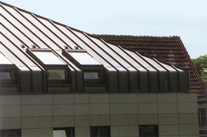 Das Dachdetail vermittelt einen Eindruck der Handwerksarbeit mit Übergängen, Anschlüssen und den Leistenabschlüssen im Gratbereich. Die Lüftungshauben oberhalb der Dachfenster bieten eine Unterstützung der Belüftung. Den gleichen Effekt erreicht man besser durch entsprechende Gestaltung der hölzernen Unterkonstruktion (z.B. Querlüftung), ohne die Dachfläche zu durchbrechen. (Foto: Rheinzink)