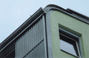 Bild 5: Dachentwässerung im Übergangsbereich von geschwungener Metallbedachung und Wellprofil-Fassade.