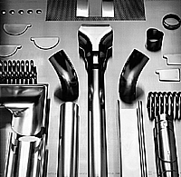 Bild 1: Zylindrische Regenfallrohre der neuesten Generation nach DIN EN 612, mit hochfrequenzgeschweißten Nähten; in Verbindung mit ebenfalls genormten Zubehörteilen als "maßgeschneidertes" metallisches Dachentwässerungssystem. (Foto Rheinzink)