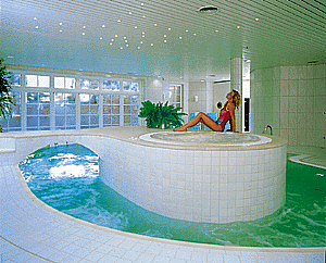 Whirlpool-Ebene in einem Schwimmbad mit Brückenzugang.