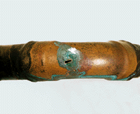 Bild 1: Lochkorrosion im Außenbogen eines 90°-Fittings.