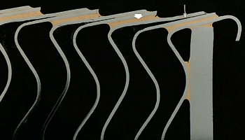 Bild 10: Randbereich eines Wärmetauschers mit lotfreiem Spalt (dünner Pfeil) und mit Kupferlot gefüllten Spalten (dicker Pfeil).