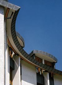 Bild 1: Architektonisches Formgefühl und handwerkliches Können kennzeichnen diese elegant geschwungene Dachrandeinfassung an einem Hotelgebäude, ausgeführt in Winkelstehfalztechnik.