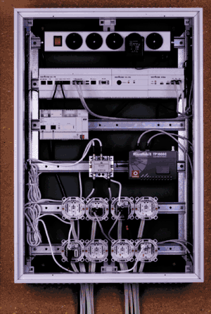 Die zentral angeordnete Unterverteilung ist so großzügig bemessen, dass genügend Hutschienen vorhanden sind, um wie hier die Telekommu- nikation und Haussprechanlage (2. Hutschiene von oben), die Spannungs- versorgung für den EIB (3. Schiene), die Radio/TV-Signale (4. Schiene) sowie die Geräteeinsätze der Sternverdrahtung übersichtlich anzuordnen.