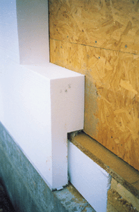 Bild 3: Anschlussdetail Kellerdecke. Auf dem Betonsockel liegt die Kellerdecke als Holzbalkendecke auf. Das Wärmedämmverbundsystem wird über die Deckenstirn heruntergeführt, sodass die Dämmung der Außenwand lückenlos in die Dämmung der Kellerdecke übergeht.