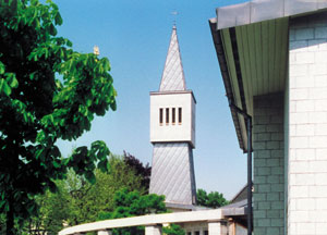 Bild 8: Spiegeldeckung, diagonal verlegt, kennzeichnet den Kirchturm dieses Gemeindezentrums in Remscheid. Die metallische Dachhaut harmoniert gut mit den angrenzenden Werkstoffen des Gebäudes. Foto: TPP