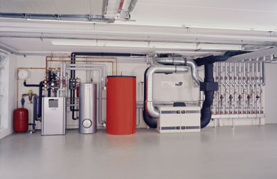 Die innovative Technik für Heizung, Lüftung und Warmwasser ist hier gut zugänglich installiert. Von links nach rechts: Membranausdehnungsgefäß (MAG), Wärmepumpe, Edelstahl-Warmwasserspeicher (300 Liter), Pufferspeicher für die Wärmepumpe, Lüftungsgerät und Verteiler-/Sammlerkombination.