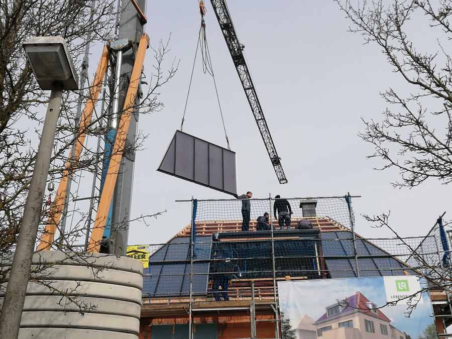 Montage der Solarkollektoren auf dem Dach und der Gaube des ersten Mehrfamilien-Sonnenhauses in Regensburg. Bild: Lebensraum³ 