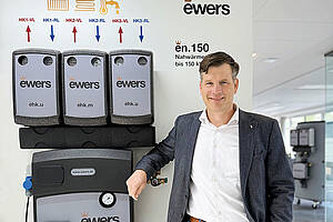 Christian Brüggemann, Technischer Geschäftsführer von Ewers, vor den ausgestellten Nahwärme­produkten, die er gemeinsam mit seinem Team entwickelt hat. Bild: Ewers
