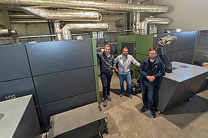 Andreas Strobl (v.l.), Gesellschafter von Strobl Heizungsbau aus Velden an der Vils; Maximilian Maier, Forstunternehmer und Nahwärmenetzbetreiber aus Triftern und Thomas Moser, Produktmanager der HDG Bavaria mit dem „M300-400“ und „Compact 149“. Bild: HDG Bavaria