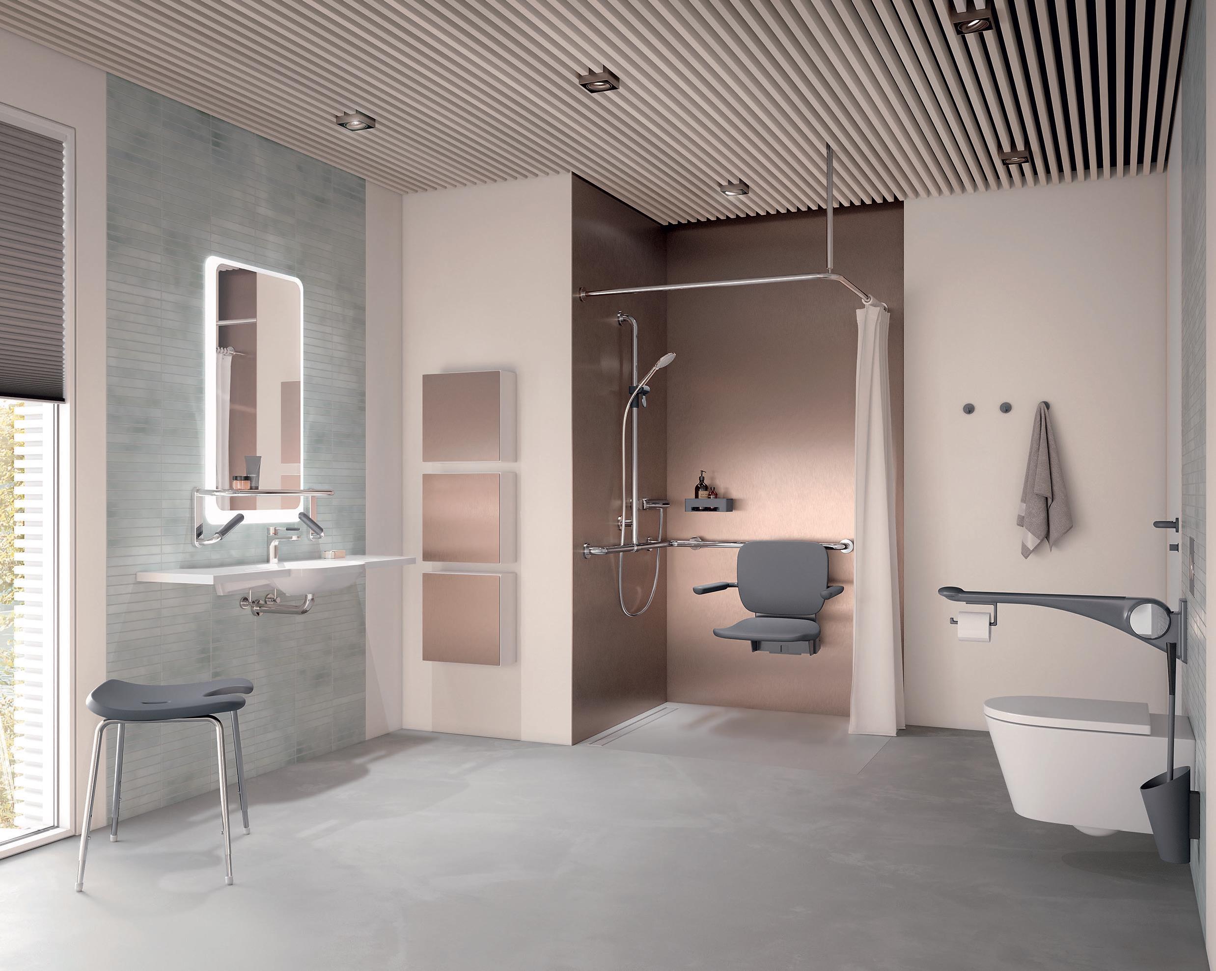 Ein barrierefreies Bad setzt sich aus zahlreichen Ausstattungsgegenständen und Accessoires zusammen, z. B. einem knapp über dem Waschtisch angebrachten Spiegel, einem oder zwei WC-Klappgriffen, weitere Haltegriffe im Bad oder einem Duschsitz. Komfortabel für die Hilfsperson, wenn das Bad großzügig gestaltet ist. (HEWI)