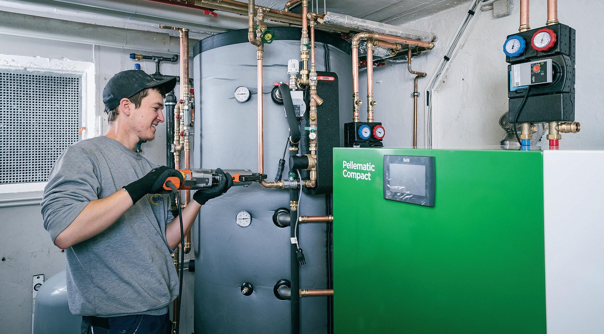 Installation einer Pelletheizung. Beim Austausch der alten Ölheizung kombinierte der Bauherr den neuen Pelletkessel mit einer Photovoltaikanlage (Heizstab im Pufferspeicher).