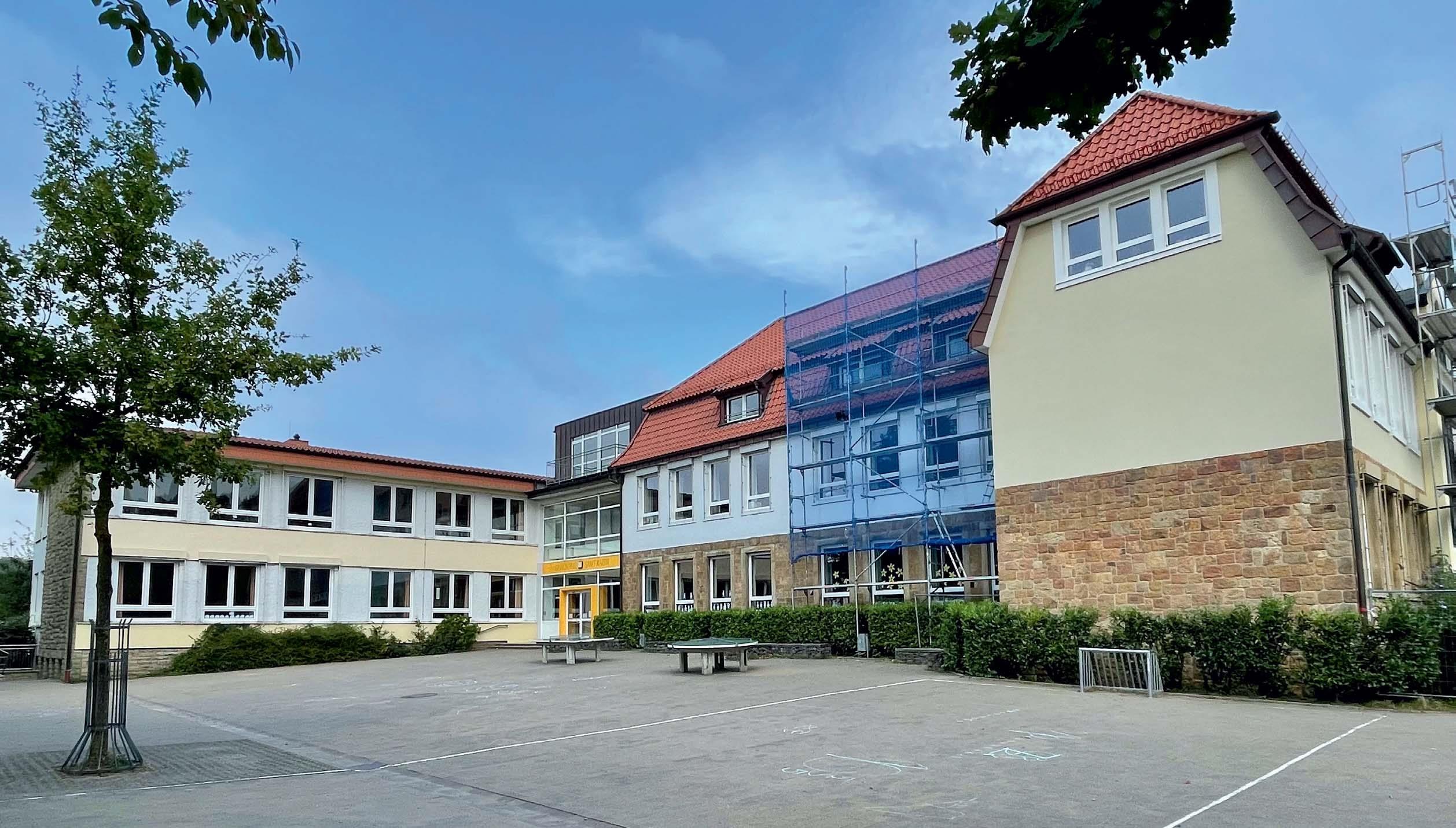 Außenansicht der Grundschule St. Martin a. T. W. mit historischem Altbau und modernem Neubau. Beide Gebäudeteile wurden vollständig funkbasiert mit Komponenten von ELTAKO ausgestattet und über die wibutler Smart Building Plattform vernetzt. Eine zeitgemäße Lösung für die Verwaltung digitaler Gebäudetechnik muss drei zentrale Ziele erreichen. (wibutler)